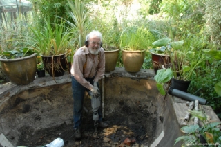 Breaking the concrete pond bottom.